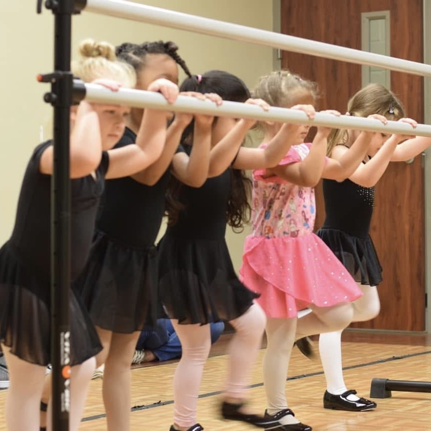 Young ballet students practicing at the barre